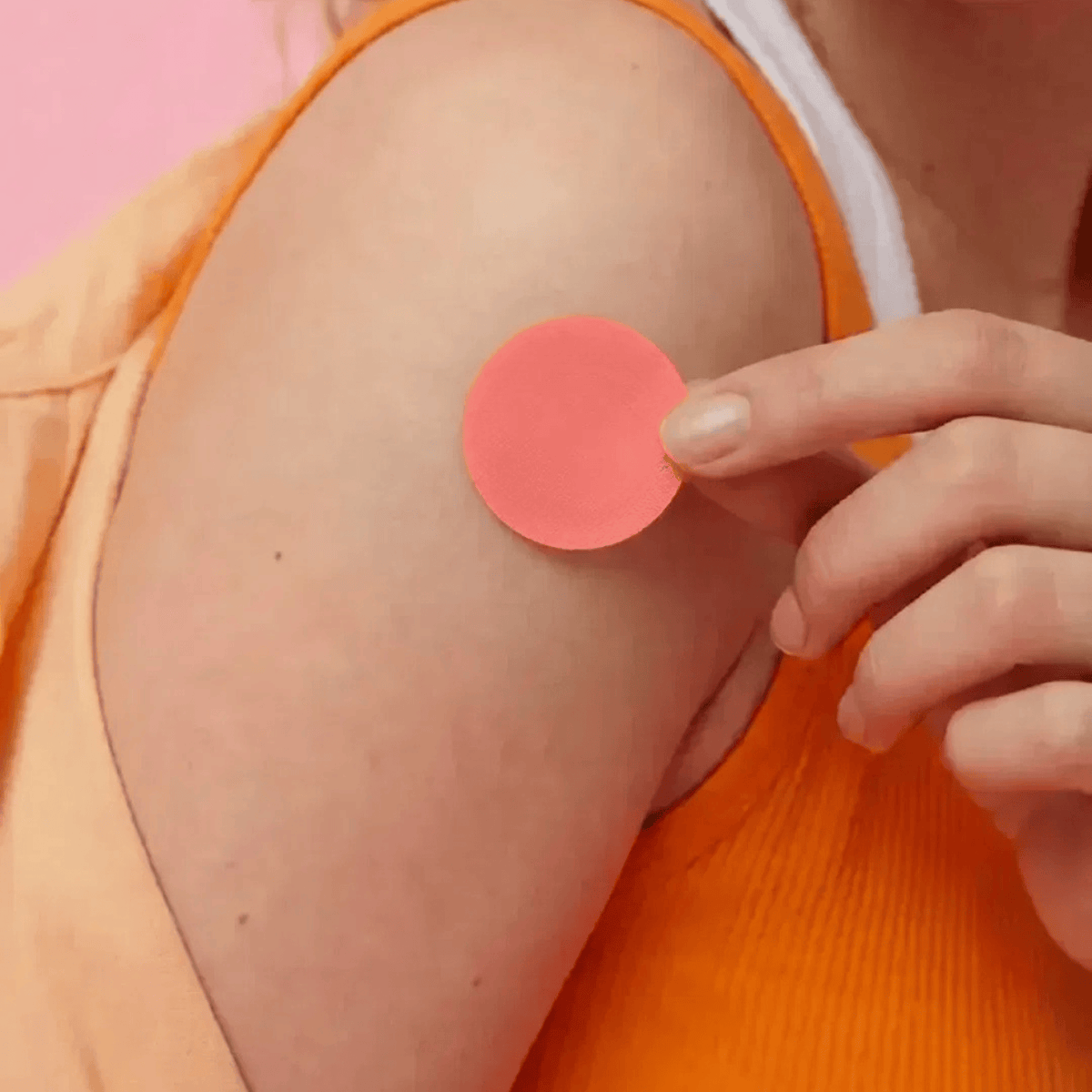 A close-up of a person's shoulder with a round pink berberine patch applied to the skin, while another hand holds a matching pink patch near the shoulder.